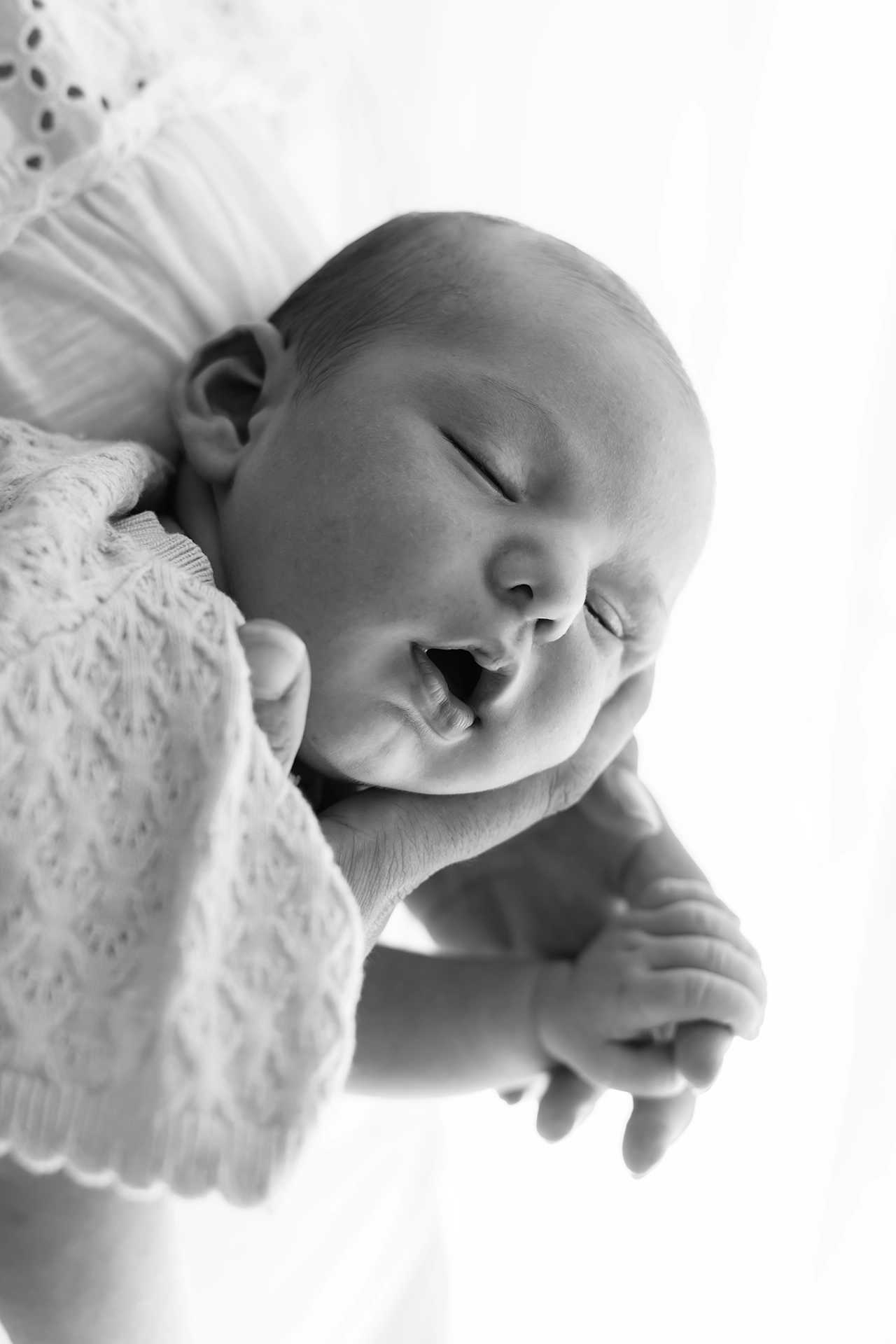 imagen de un bebé recién nacido sobre los brazos de su madre, en blanco y negro, fotógrafo en silla valencia