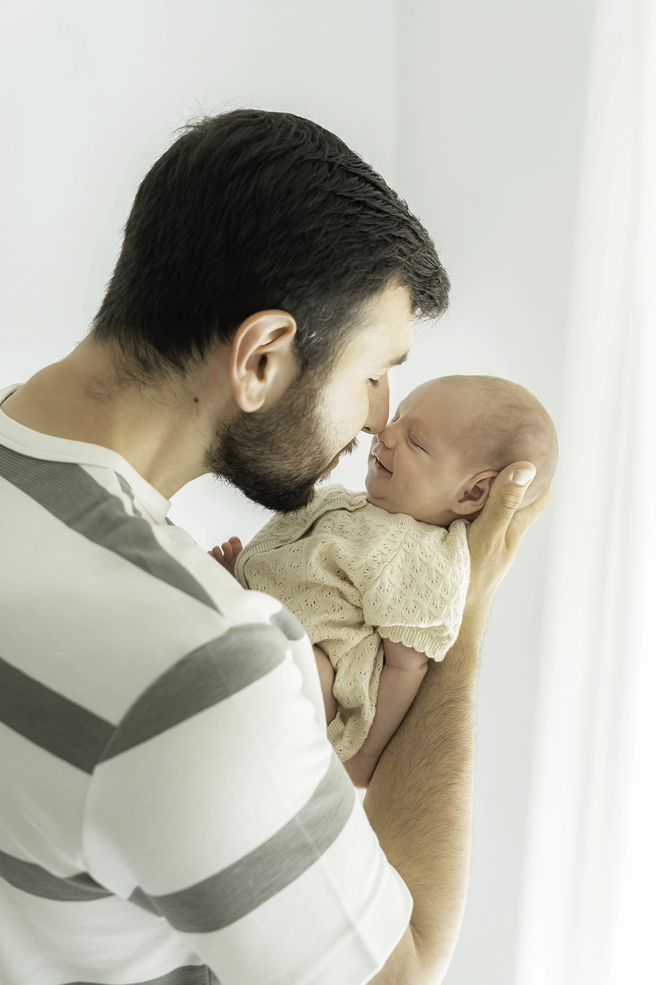 reportaje de fotos newborn - fotógrafo en Silla, Valencia foto de recien nacido junto a su padre, tonos neutros, fotografía en estudio Silla