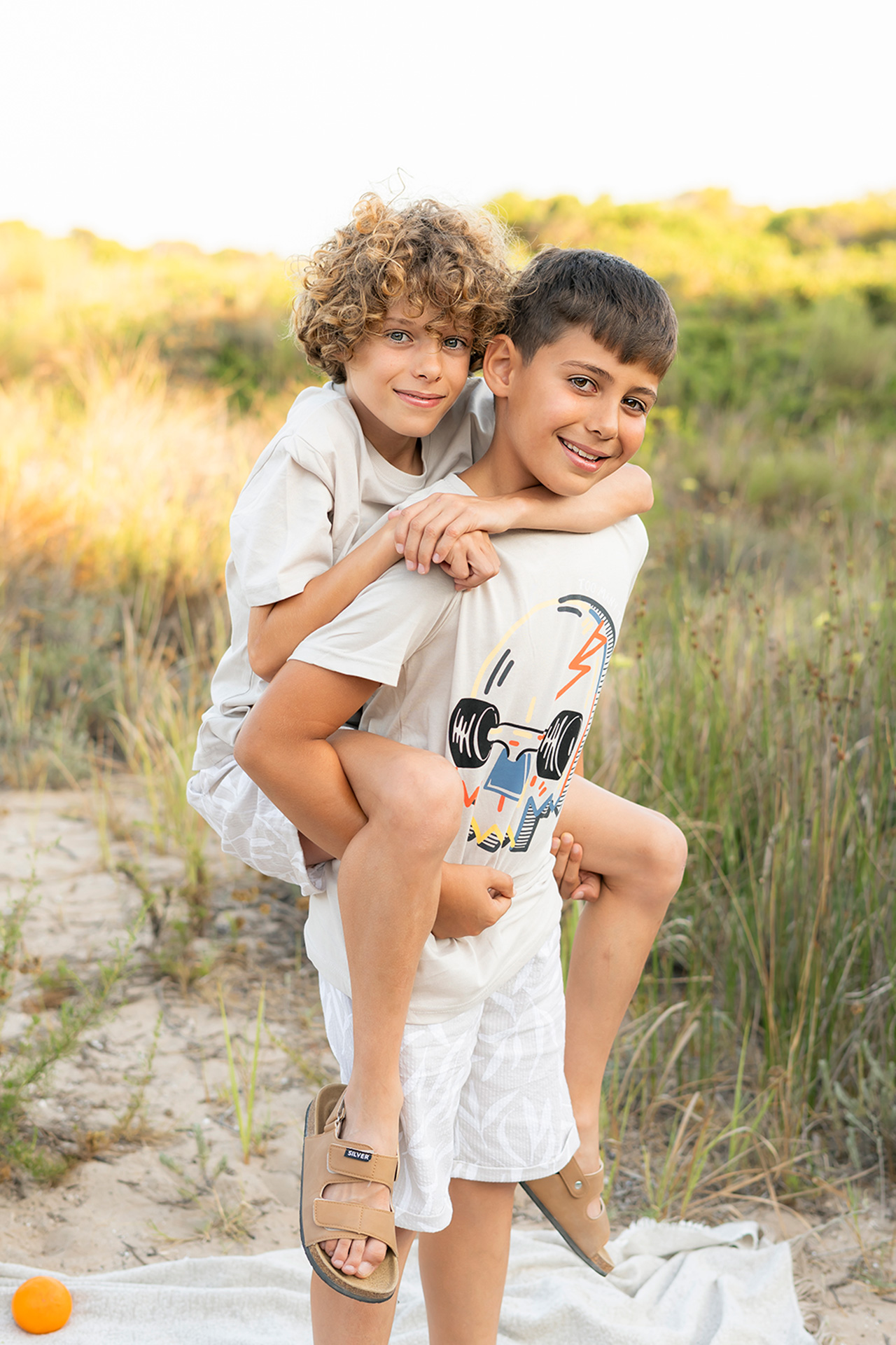 Reportaje de fotos en exterior en Valencia - Fotógrafo de familias en Valencia foto de dos hermanos pequeños en la playa jugando