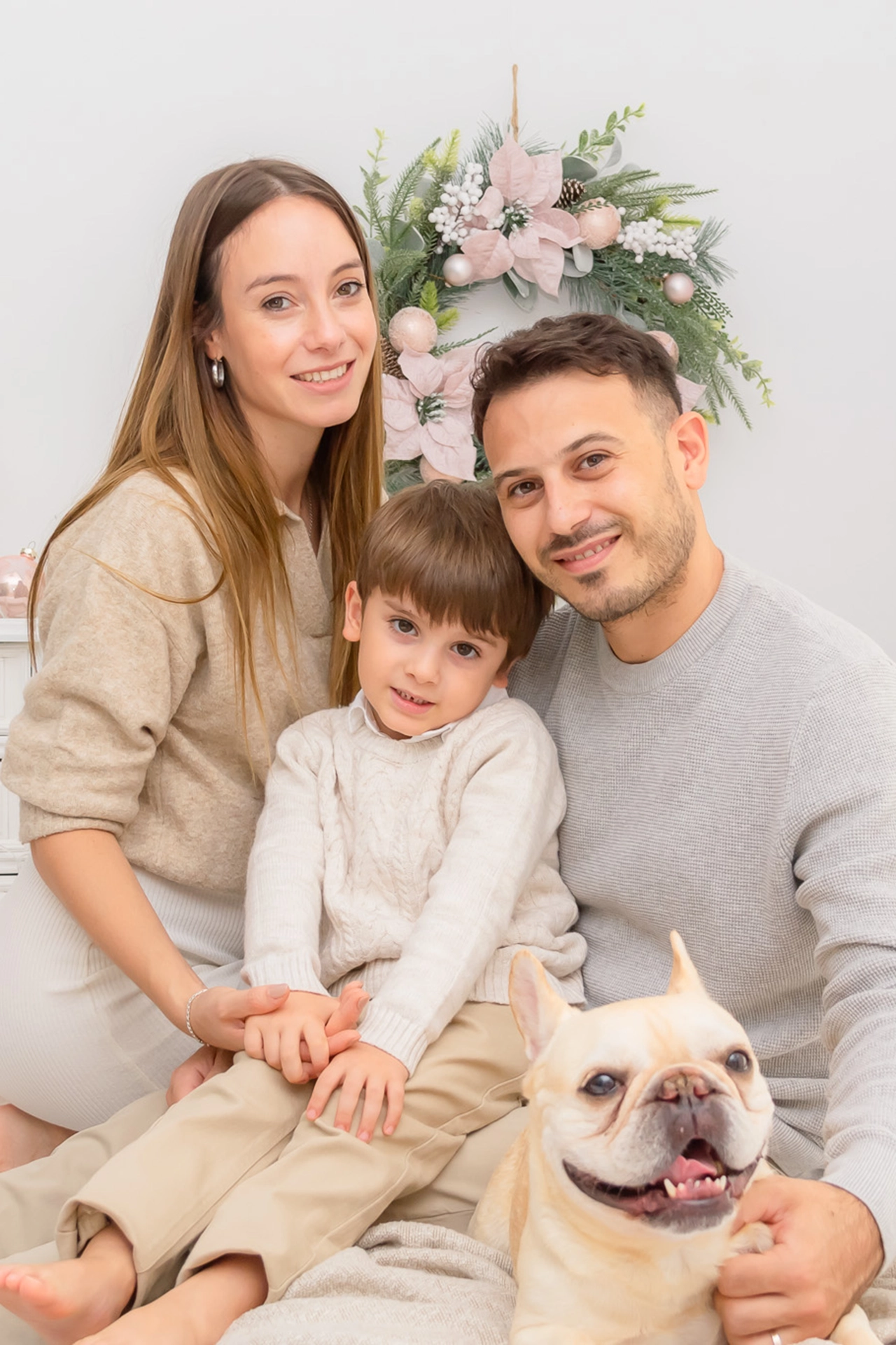 Fotografía familiar de Navidad en Valencia Familia disfrutando una sesión navideña con decorado elegante en estudio fotográfico