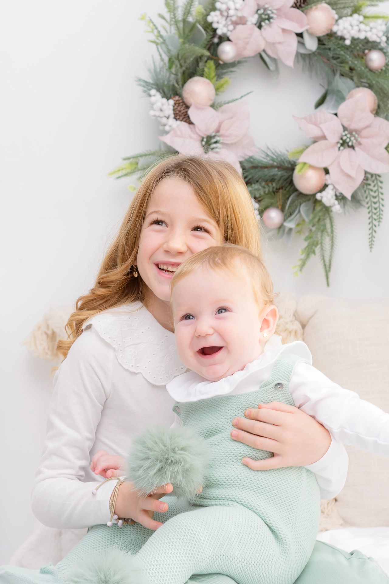 Sesión de fotos de navidad valencia fotografia de navidad en valencia, foto de dos hermanas pequeñas en escenario de navidad moderno y minimalista con tonos pasteles