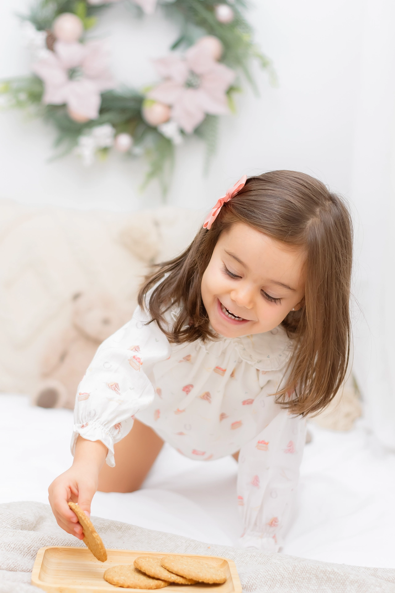 Fotógrafa infantil en Valencia – Campaña de Navidad Niña pequeña posando en un decorado navideño con luces cálidas y ambiente acogedor