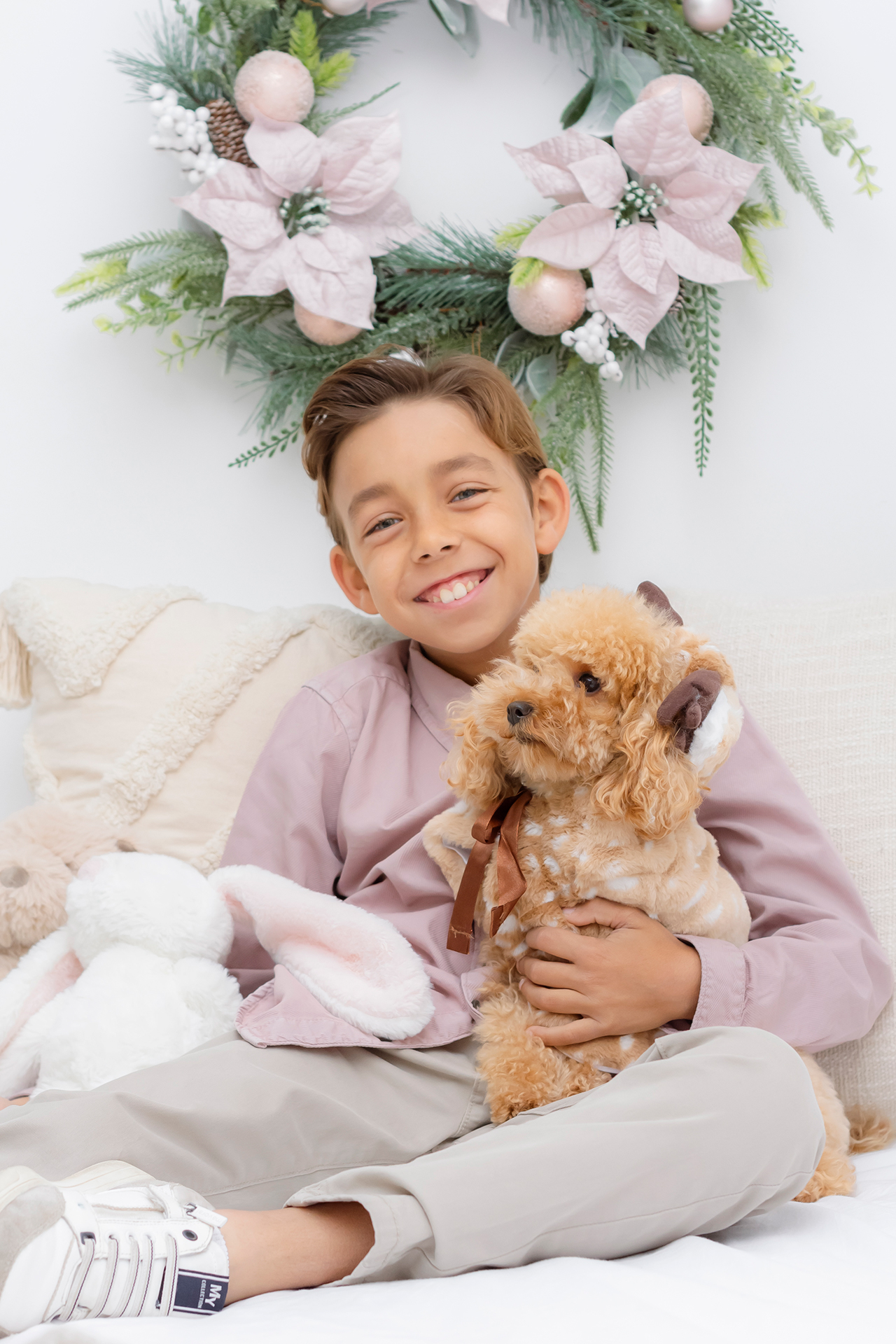 Sesiones de navidad en Valencia- fotógrafo valencia niño pequeño en sesión de navidad junto a su perro peludito pequeño, estudio de fotos acogedor en valencia