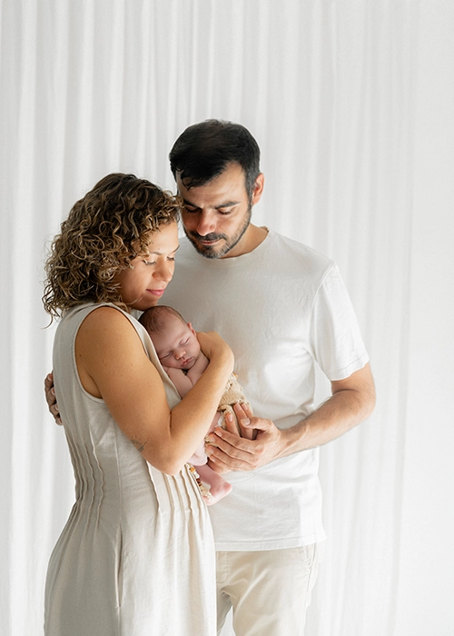 pareja con su bebe recien nacido en brazos en su primer sesion de fotos