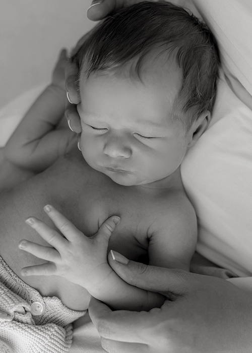 foto en blanco y negro de bebe dormido sobre regazo de la madre
