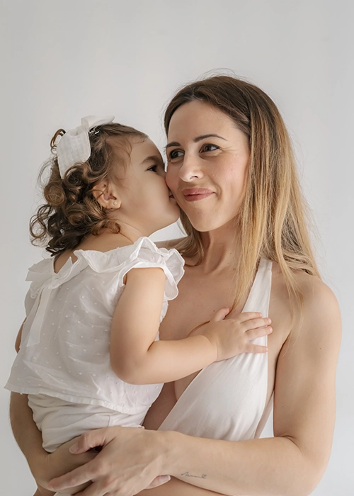 niña dando beso a su madre
