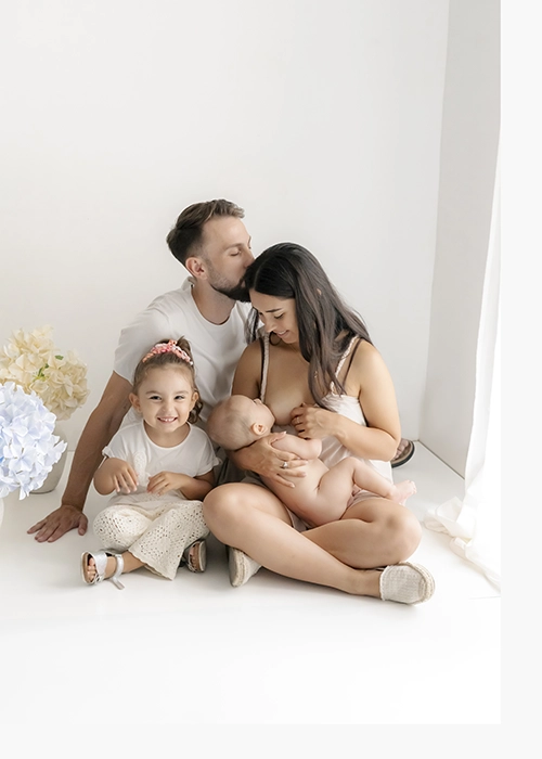 familia con padres niña sonriendo y niño sentados en el suelo