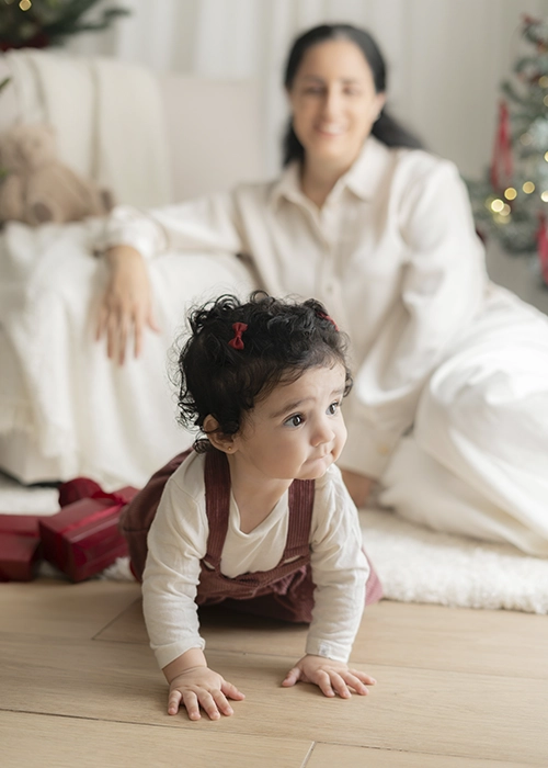 niña bebe de 9 meses gateando escenario de navidad blanco y burdeos