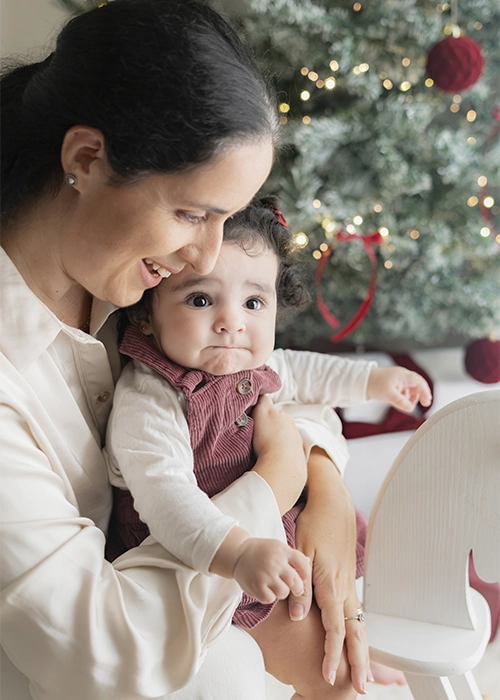 madre junto a su hija bebe en escenario de navidad